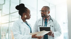 doctors with ipad and pa paperwork talking